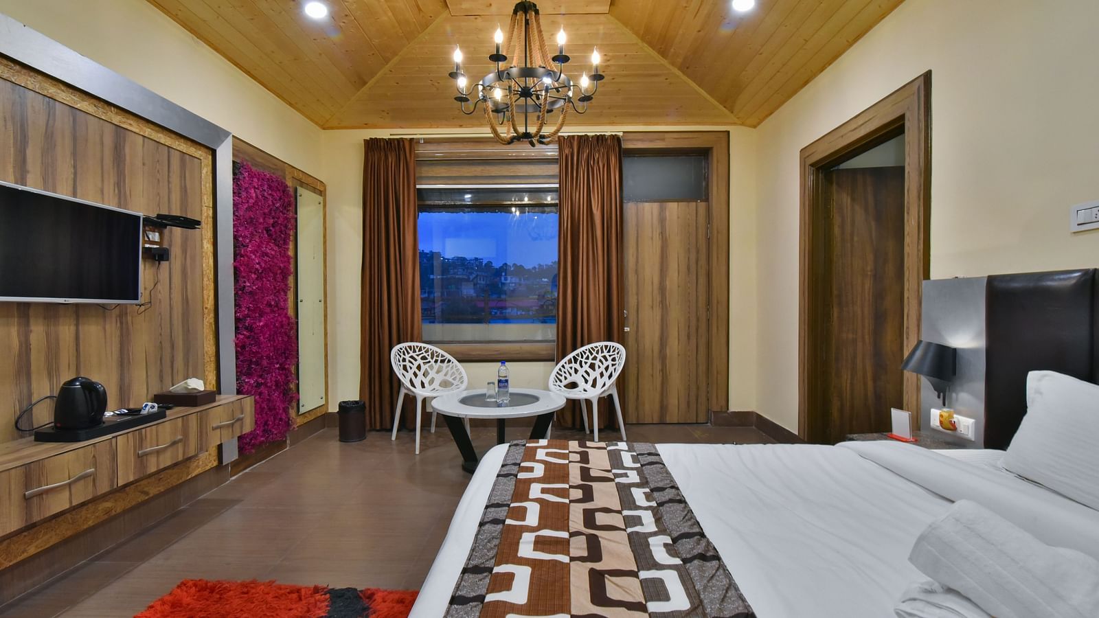 Family suite at DLS Dalhousie Valley Resort with a king size bed, a table, chairs and a balcony 